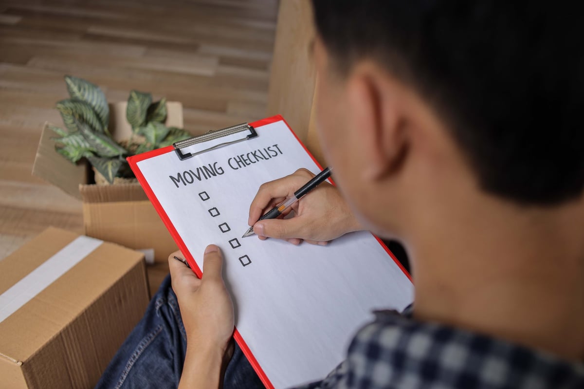 Closeup of Man Prepare to Relocate and Move to New House with Checklist and Clipboard