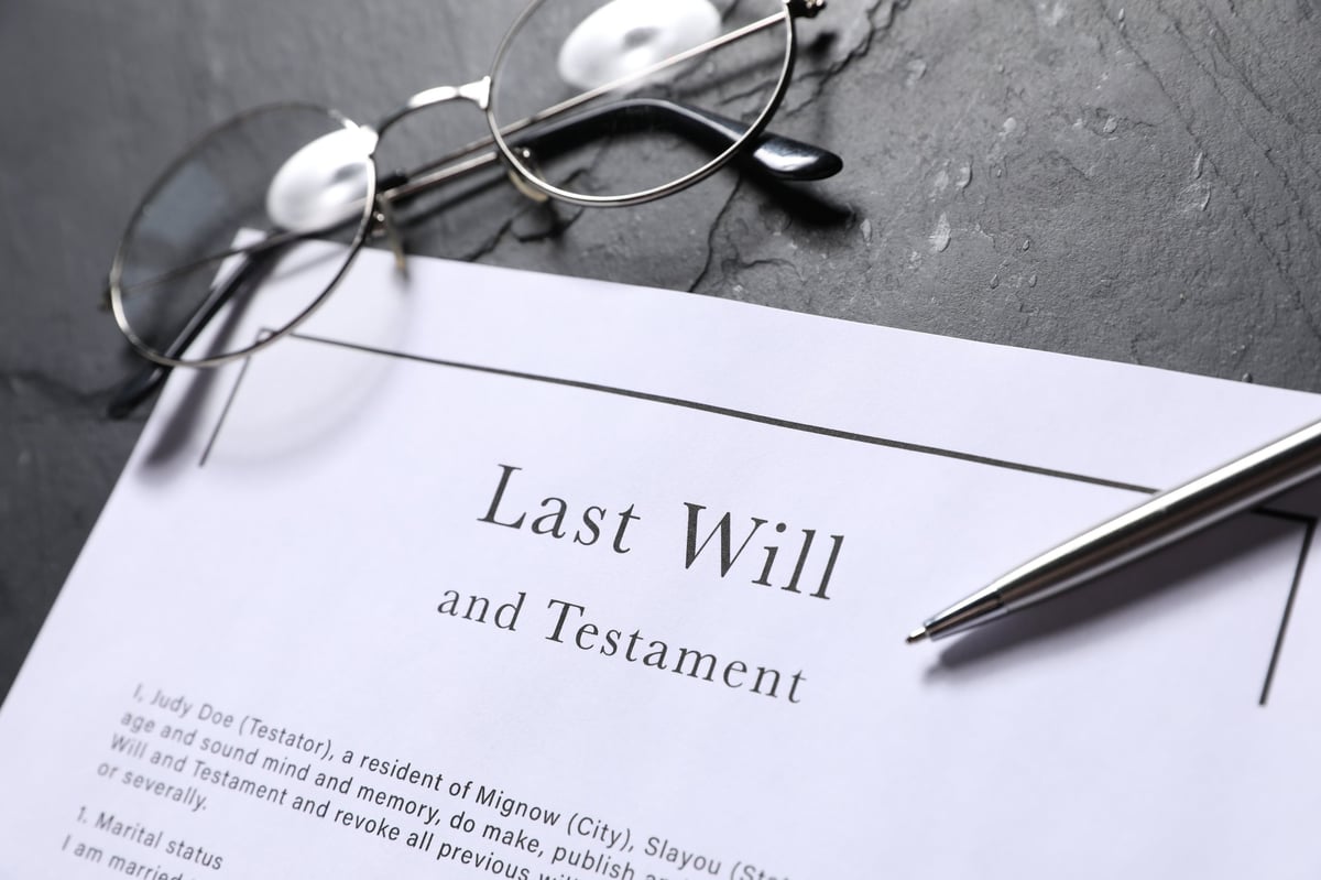 Last Will and Testament, glasses and pen on black table, closeup