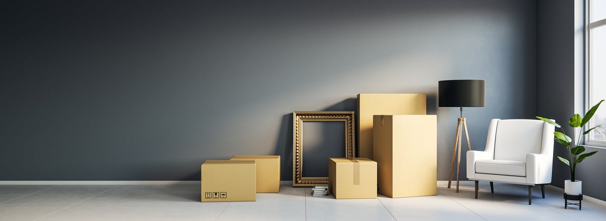 Room with cardboard boxes, armchair and lamp in modern style on dark wall background, concept of moving and relocation