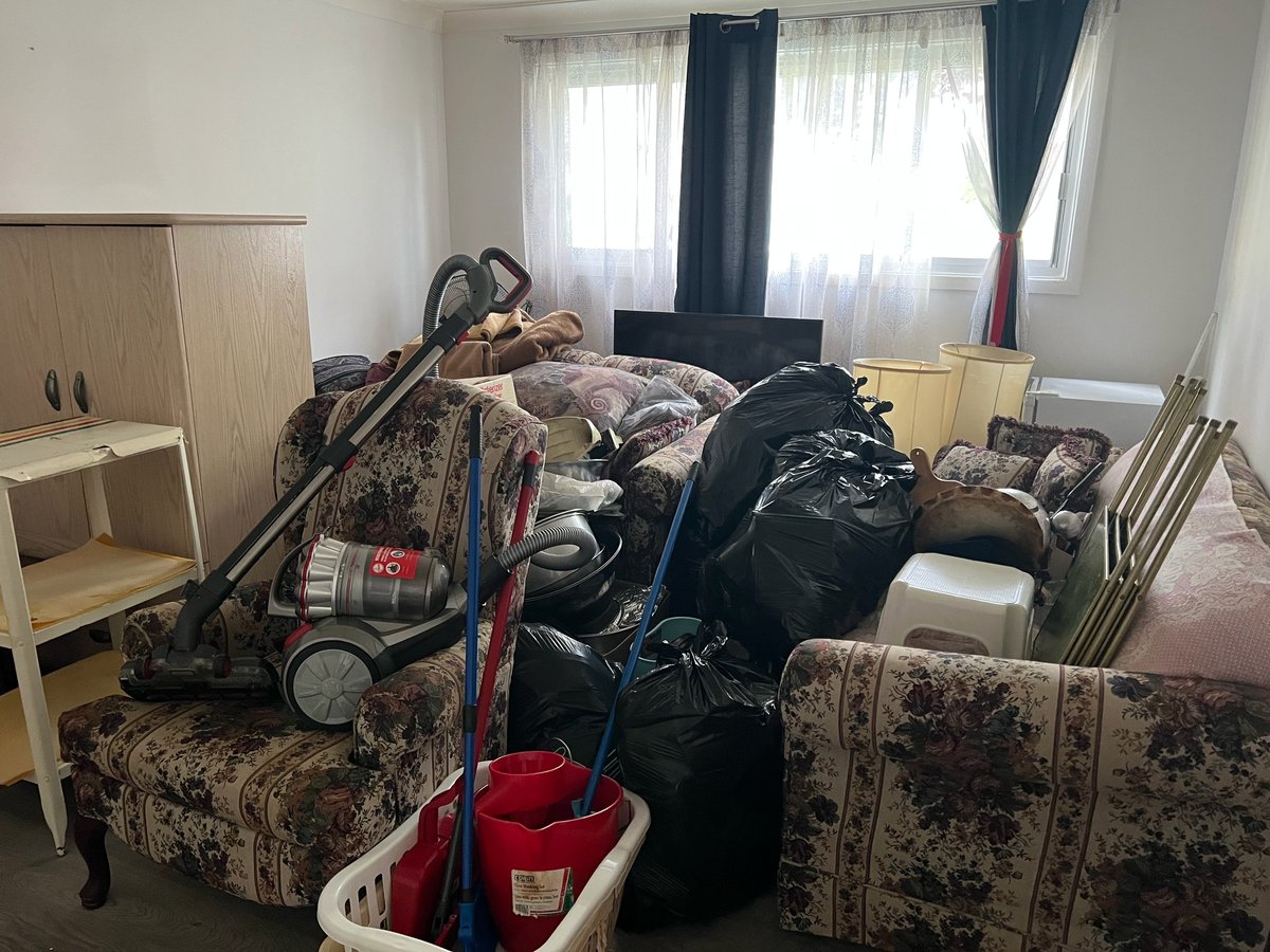 Cluttered bedroom during an estate cleanout in Ottawa — piles of belongings, clothing and furniture awaiting removal by JunkPal.